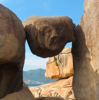 Балансирующий камень между скалами в Саду камней Хон Чонг, Нячанг — вид на море и горы