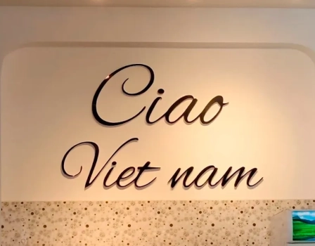 Фасад ресторана Ciao Vietnam в Нячанге вечером, люди заходят внутрь и сидят за столиками